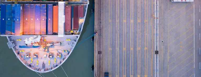 Top view of international port with Crane loading containers in import export business logistics