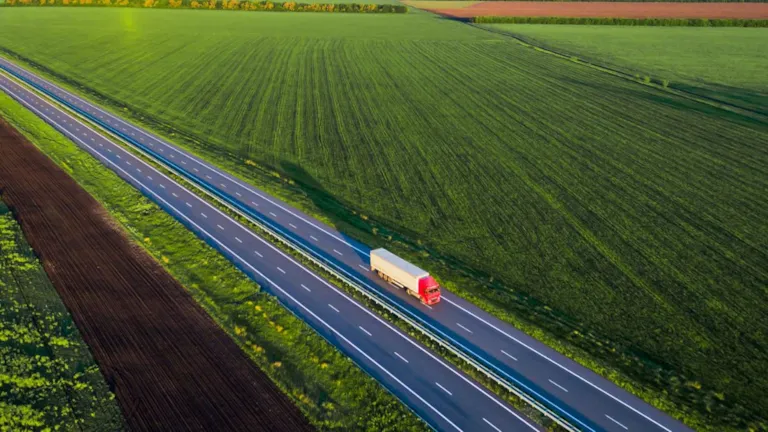Truck on road between fields