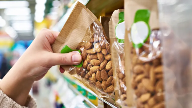 hand grabbing pack of almond
